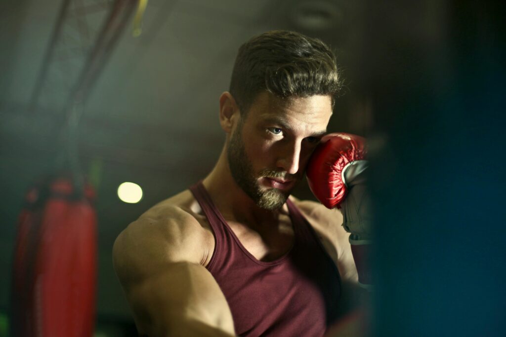 Bearded male boxer in gym focusing intensely during training session.